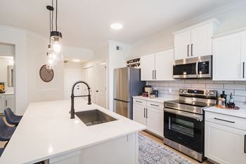 A kitchen with white cabinetry and stainless steel appliances